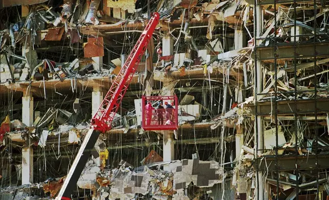FILE - Rescue workers dig through the rubble from the Alfred P. Murrah Federal Building explosion in downtown Oklahoma City on April 20, 1995. (AP Photo/J.Pat Carter, File)
