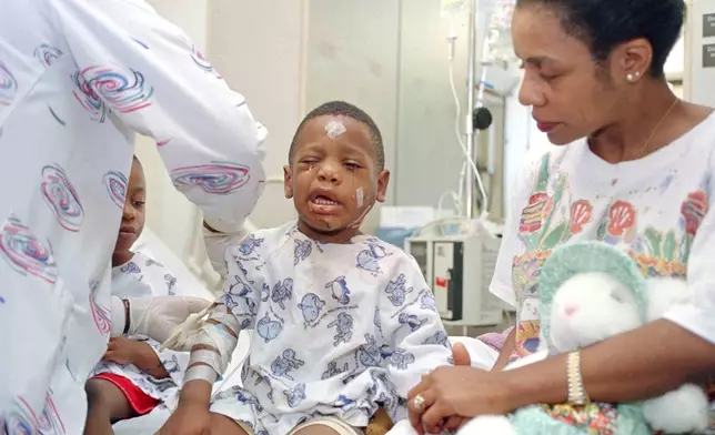 FILE - Davetta Green comforts her son, James Green, as a nurse removes an I.V. at Presbyterian Hospital in Oklahoma City on April 20, 1995. James was injured when he and his mother were in the YMCA building across the street from the Alfred P. Murrah Federal Building when it was bombed. (AP Photo, File)