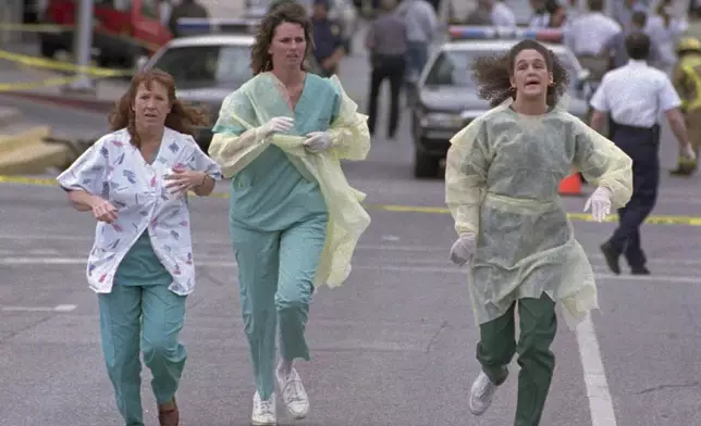 FILE - Medical assistants Janet Froehlich, Wilma Jackson and Kerri Albright run from the Alfred P. Murrah Federal Building after being told another bomb device had been found on April 19, 1995, in Oklahoma City. (AP Photo/David J. Phillip, File)