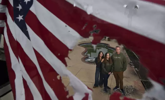 Keith and Rachel McNett stand with their daughter Teagan, left, where their house burned from the Mountain Fire Wednesday, April 16, 2025, in Camarillo, Calif. (AP Photo/Wally Skalij)