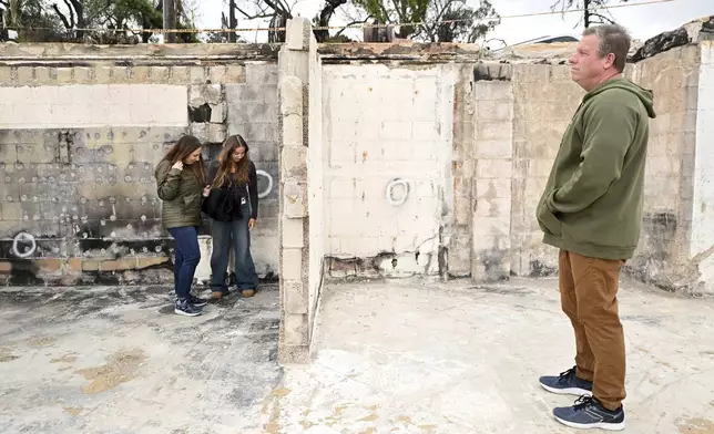 Keith and Rachel McNett along with daughter Teagan, center, visit there house that burned in the Mountain Fire Wednesday, April 16, 2025, in Camarillo, Calif. (AP Photo/Wally Skalij)