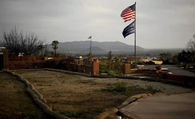 Flags fly along Esteban Drive after the Mountain Fire burned through the area Wednesday, April 16, 2025, in Camarillo, Calif. (AP Photo/Wally Skalij)