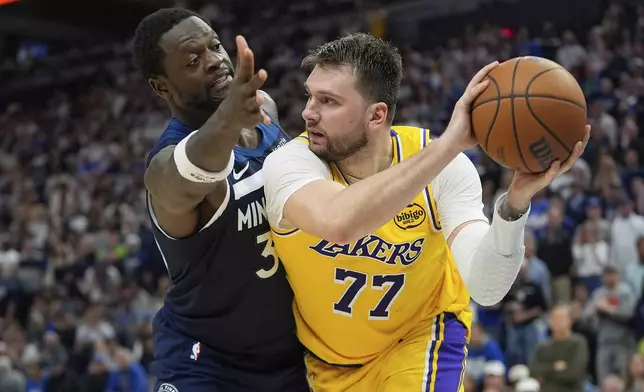 Los Angeles Lakers guard Luka Doncic (77) looks to pass as Minnesota Timberwolves forward Julius Randle (30) defends during the second half of Game 3 of an NBA basketball first-round playoff series, Friday, April 25, 2025, in Minneapolis. (AP Photo/Abbie Parr)