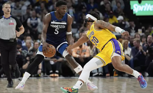 Minnesota Timberwolves guard Anthony Edwards (5) works toward the basket as Los Angeles Lakers guard Jordan Goodwin (30) defends during the first half of Game 3 of an NBA basketball first-round playoff series, Friday, April 25, 2025, in Minneapolis. (AP Photo/Abbie Parr)