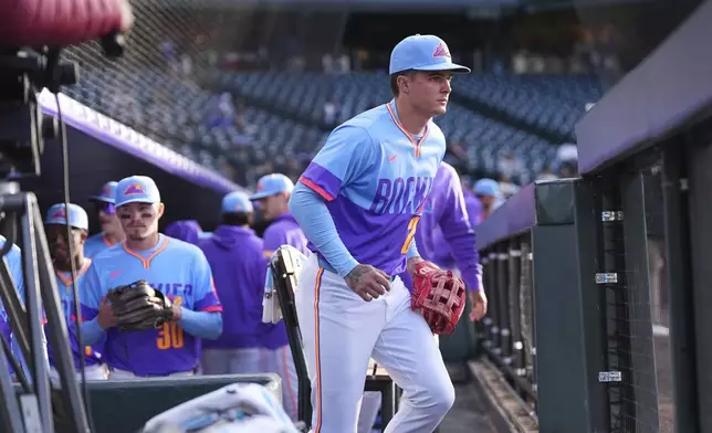 Wearing the team' new "City Connect" uniform, Colorado Rockies center fielder Mickey Moniak takes the field in the first inning of Game 2 of a split baseball doubleheader against the Washington Nationals, Sunday, April 20, 2025, in Denver. (AP Photo/David Zalubowski)