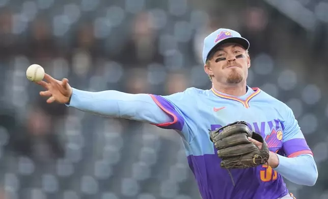 Colorado Rockies shortstop Aaron Schunk throws to first base to put out Washington Nationals' Dylan Crews in the fourth inning of Game 2 of a split baseball doubleheader Sunday, April 20, 2025, in Denver. (AP Photo/David Zalubowski)