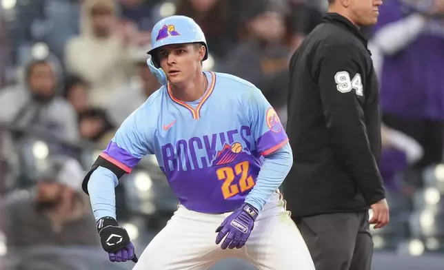 Colorado Rockies' Mickey Moniak gestures to the dugout after hitting a triple to drive in two runs off Washington Nationals starting pitcher Brad Lord in the fourth inning of Game 2 of a split baseball doubleheader Sunday, April 20, 2025, in Denver. (AP Photo/David Zalubowski)