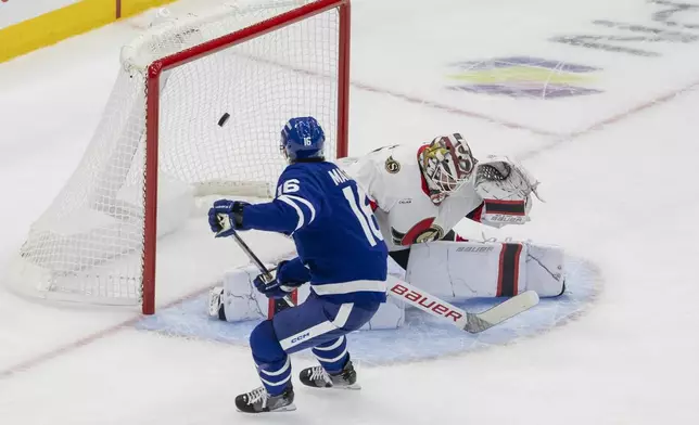 Toronto Maple Leafs' Mitch Marner (16) scores on Ottawa Senators goaltender Linus Ullmark (35) during the first period of an NHL hockey playoff action in Toronto, Sunday, April 20, 2025. (Nick Iwanyshyn/The Canadian Press via AP)