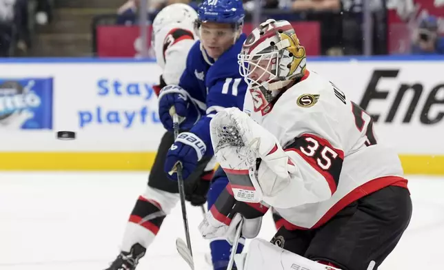 Ottawa Senators' goaltender Linus Ullmark (35) makes the save as Toronto Maple Leafs' Max Domi (11) tries to deflect the puck during the second period of an NHL hockey playoff game in Toronto, Sunday, April 20, 2025. (Frank Gunn/The Canadian Press via AP)