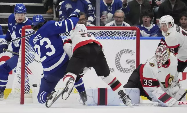 Toronto Maple Leafs' Matthew Knies (23) scores a goal on Ottawa Senators' goaltender Linus Ullmark (35) as Artem Zub (2) tries to defend during third period NHL playoff action in Toronto, on Sunday, April 20, 2025. (Frank Gunn/The Canadian Press via AP)