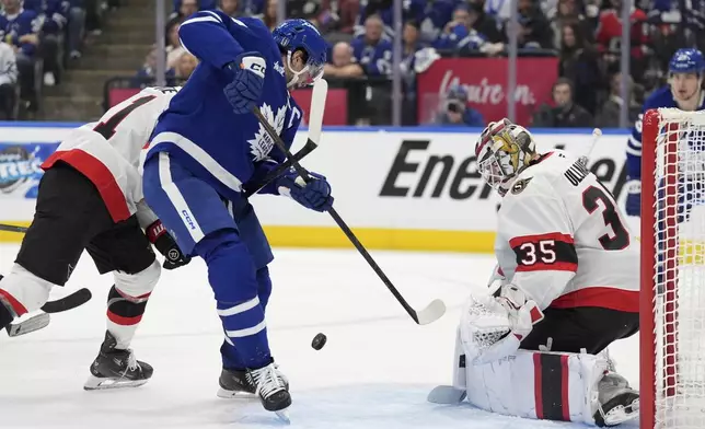 Toronto Maple Leafs' Auston Matthews (34) is stopped by Ottawa Senators' goaltender Linus Ullmark (35) during the second period of an NHL hockey playoff game in Toronto, Sunday, April 20, 2025. (Frank Gunn/The Canadian Press via AP)