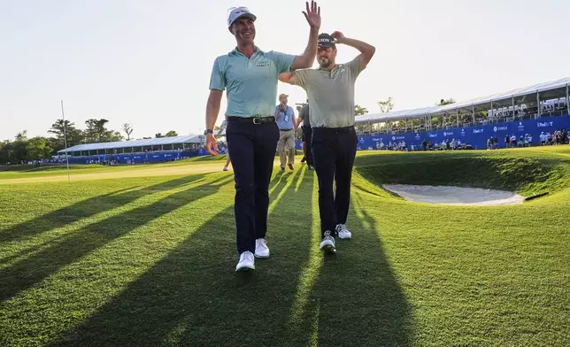 Ben Griffin, left, walks off the 18th green with teammate Andrew Novak, after they won the PGA Zurich Classic golf tournament at TPC Louisiana in Avondale, La., Sunday, April 27, 2025. (AP Photo/Gerald Herbert)