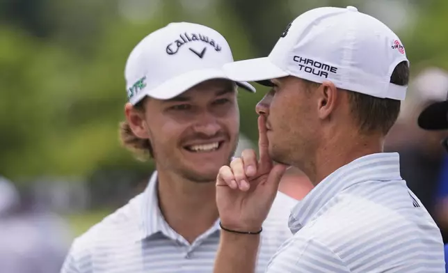 Rasmus Hojgaard, of Denmark, talks with his twin brother and teammate Nicolai Hojgaard, of Denmark, on the 2nd hole during the final round of the PGA Zurich Classic golf tournament at TPC Louisiana in Avondale, La., Sunday, April 27, 2025. (AP Photo/Gerald Herbert)