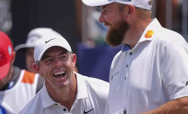 Rory McIlroy, of North Ireland, left, reacts as he and teammate Shane Lowry, of Ireland, ready to tee of the first hole during the final round of the PGA Zurich Classic golf tournament at TPC Louisiana in Avondale, La., Sunday, April 27, 2025. (AP Photo/Gerald Herbert)