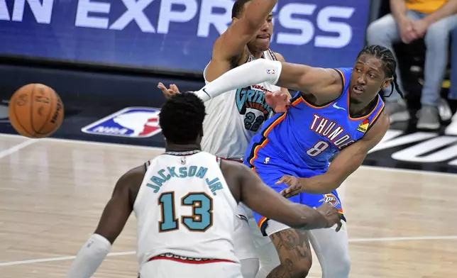 Oklahoma City Thunder forward Jalen Williams (8) passes the ball between Memphis Grizzlies guard Desmond Bane (22) and forward Jaren Jackson Jr. (13) in the second half of Game 3 of an NBA first-round playoff series Thursday, April 24, 2025, in Memphis, Tenn. (AP Photo/Brandon Dill)