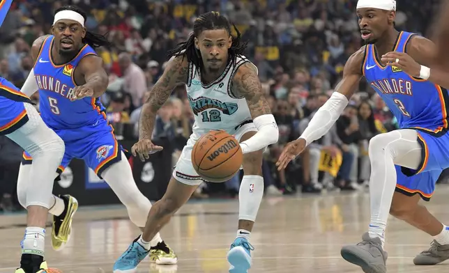 Memphis Grizzlies guard Ja Morant (12) handles the ball between Oklahoma City Thunder guards Shai Gilgeous-Alexander (2) and Luguentz Dort (5) in the first half of Game 3 of an NBA first-round playoff series Thursday, April 24, 2025, in Memphis, Tenn. (AP Photo/Brandon Dill)