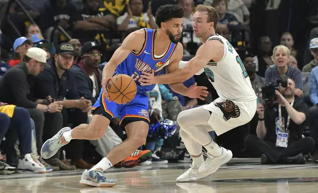 Oklahoma City Thunder guard Ajay Mitchell (25) handles the ball against Memphis Grizzlies guard Luke Kennard, right, in the first half of Game 3 of an NBA first-round playoff series Thursday, April 24, 2025, in Memphis, Tenn. (AP Photo/Brandon Dill)