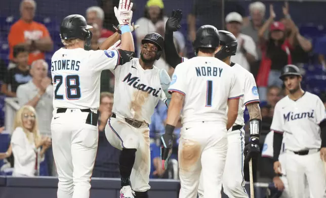 Miami Marlins' Kyle Stowers (28) is met by second baseman Otto Lopez, second from left, after hitting a three run home run during the seventh inning of a baseball game against the Cincinnati Reds, Monday, April 21, 2025, in Miami. (AP Photo/Lynne Sladky)