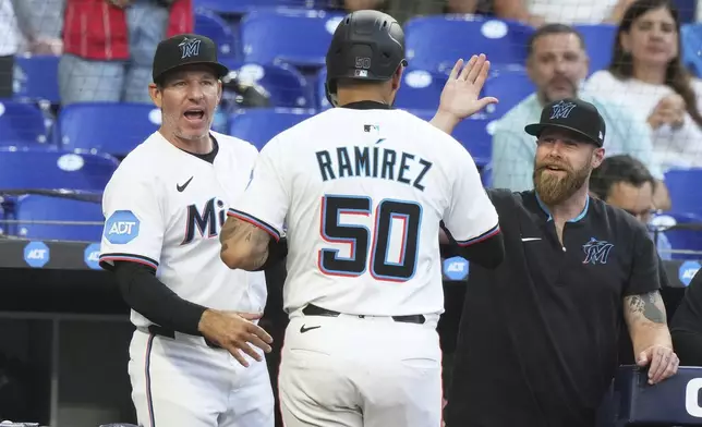 Miami Marlins' Agustin Ramirez (50) is congratulated after scoring on a single hit by Ronny Simon during the second inning of a baseball game against the Cincinnati Reds, Monday, April 21, 2025, in Miami. (AP Photo/Lynne Sladky)