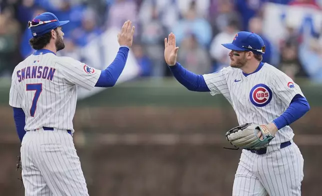 Chicago Cubs' Dansby Swanson (7), left, and Ian Happ (8) celebrate their team's win over the Arizona Diamondbacks in a baseball game Saturday, April 19, 2025, in Chicago. (AP Photo/Erin Hooley)