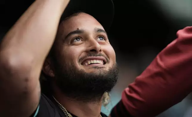 Arizona Diamondbacks pitcher Juan Morillo high-fives teammates in the dugout during the seventh inning of a baseball game against the Chicago Cubs, Saturday, April 19, 2025, in Chicago. (AP Photo/Erin Hooley)