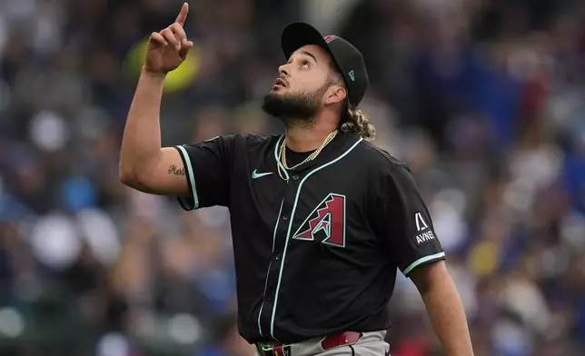 Arizona Diamondbacks pitcher Juan Morillo points skyward as he returns to the dugout during the seventh inning of a baseball game against the Chicago Cubs, Saturday, April 19, 2025, in Chicago. (AP Photo/Erin Hooley)