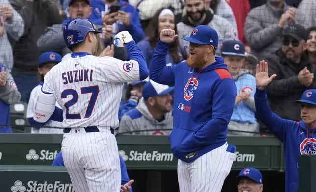 Chicago Cubs' Justin Turner, right, celebrates with designated hitter Seiya Suzuki (27) after Suzuki hit a two-run home run during the second inning of a baseball game against the Arizona Diamondbacks, Saturday, April 19, 2025, in Chicago. (AP Photo/Erin Hooley)