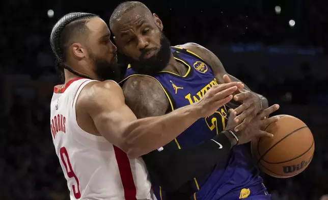 Los Angeles Lakers forward LeBron James (23) loses the ball as Houston Rockets forward Dillon Brooks (9) defends during the second half of an NBA basketball game in Los Angeles, Monday, March 31, 2025. (AP Photo/Kyusung Gong)