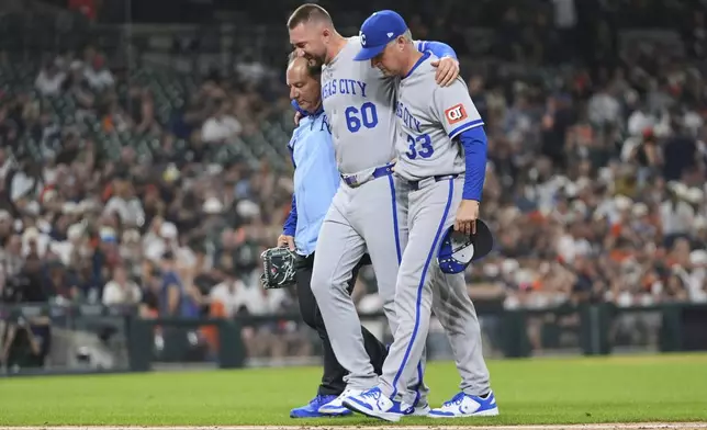 Kansas City Royals pitcher Lucas Erceg, center, is helped to the locker room after being hit by a Detroit Tigers' Riley Greene line drive in the seventh inning during a baseball game, Friday, April 18, 2025, in Detroit. (AP Photo/Paul Sancya)