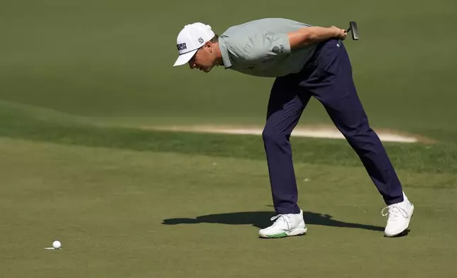Jordan Spieth looks at Tom Kim's, of South Korea, ball rest on the edge of the cup on the second hole during the first round at the Masters golf tournament, Thursday, April 10, 2025, in Augusta, Ga. (AP Photo/George Walker IV)