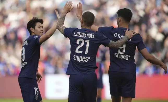 PSG's Goncalo Ramos, right, celebrates with PSG's Lucas Hernandez, center, and PSG's Lee Kang-in, left, after scoring, during the French League One soccer match between Paris Saint-Germain and Le Havre at the Parc des Princes stadium in Paris, Saturday, April 19, 2025. (AP Photo/Michel Euler)
