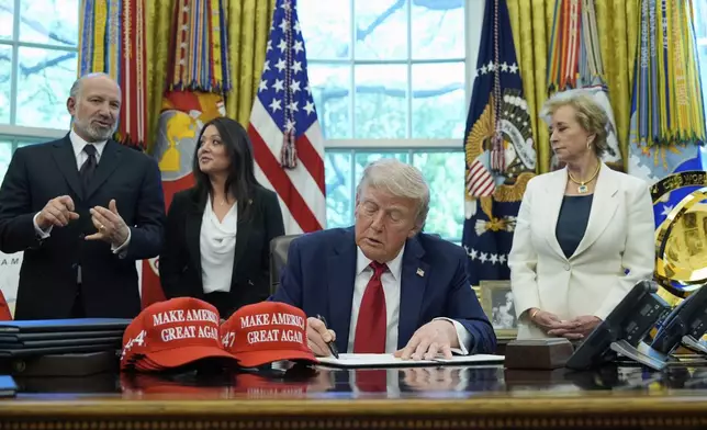 President Donald Trump holds an executive order relating to education in the Oval Office of the White House, Wednesday, April 23, 2025, in Washington, as Commerce Secretary Howard Lutnick, Labor Secretary Lori Chavez-DeRemer and Education Secretary Linda McMahon watch. (AP Photo/Alex Brandon)