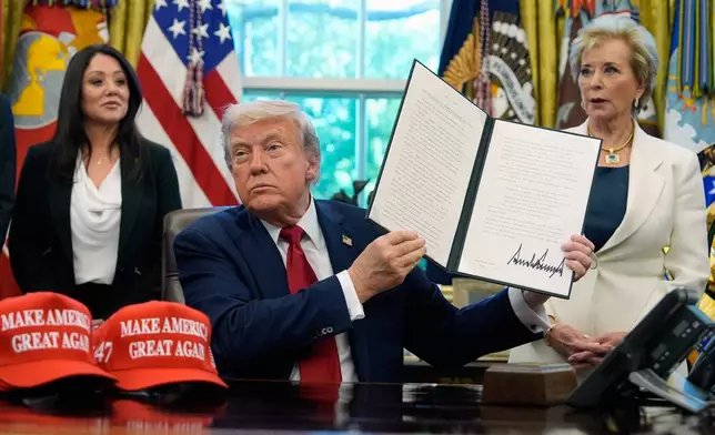 President Donald Trump holds a signed executive order relating to Historically Black Colleges and Universities in the Oval Office of the White House, Wednesday, April 23, 2025, in Washington. (AP Photo/Alex Brandon)