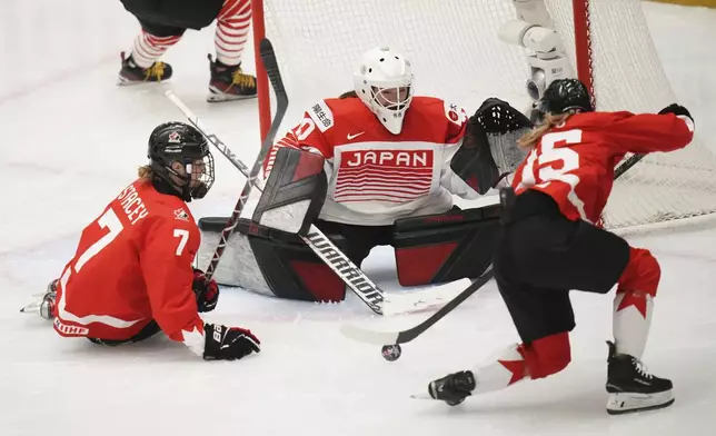 Japan's Miyuu Masuhara, center, makes a save against Daryl Watts of Canada, right, and Laura Stacey of Canada during the quarterfinal match between Canada and Japan at the Women's Ice Hockey Championships in Ceske Budejovice, Czech Republic, Thursday, April 17, 2025. (AP Photo/Petr David Josek)