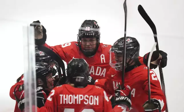 Claire Thompson of Canada, down, celebrates with teammates after scoring her sides first goal during the quarterfinal match between Canada and Japan at the Women's Ice Hockey Championships in Ceske Budejovice, Czech Republic, Thursday, April 17, 2025. (AP Photo/Petr David Josek)