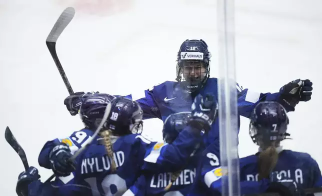 Finland's Jenniina Nylund, 2nd left, celebrates with teammates after scoring her sides first goal during the quarterfinal match between Finland and Sweden at the Women's Ice Hockey Championships in Ceske Budejovice, Czech Republic, Thursday, April 17, 2025. (AP Photo/Petr David Josek)