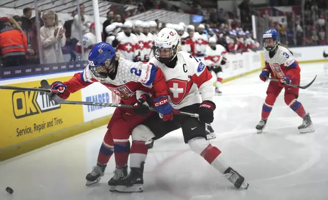 Lara Stalder of Switzerland, right, challenges Aneta Tejralova of Czech Republic during the quarterfinal match between Czech Republic and Switzerland at the Women's Ice Hockey Championships in Ceske Budejovice, Czech Republic, Thursday, April 17, 2025. (AP Photo/Petr David Josek)