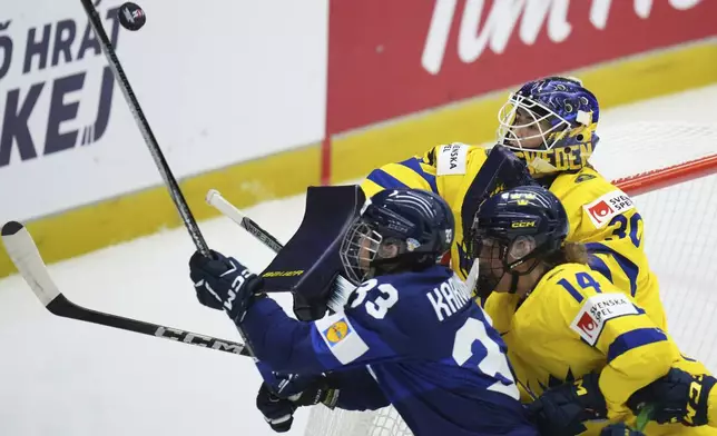 Sweden's Emma Soderberg, right, makes a save during the quarterfinal match between Finland and Sweden at the Women's Ice Hockey Championships in Ceske Budejovice, Czech Republic, Thursday, April 17, 2025. (AP Photo/Petr David Josek)