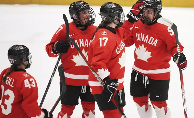 Jennifer Gardiner of Canada, right, celebrates with teammates after scoring her sides second goal during the quarterfinal match between Canada and Japan at the Women's Ice Hockey Championships in Ceske Budejovice, Czech Republic, Thursday, April 17, 2025. (AP Photo/Petr David Josek)