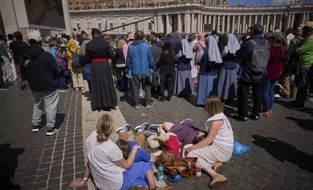 Faithful listen to mass during the funeral of Pope Francis in St. Peter's Square at the Vatican, Saturday, April 26, 2025. (AP Photo/Emilio Morenatti)