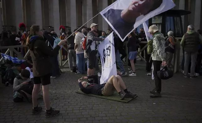 A faithful waves a flag with Carlo Acutis, the 15-year-old Italian boy who died in 2006 of leukemia and beatified in 2020, at the funeral of Pope Francis in St. Peter's Square at the Vatican, Saturday, April 26, 2025. (AP Photo/Emilio Morenatti)