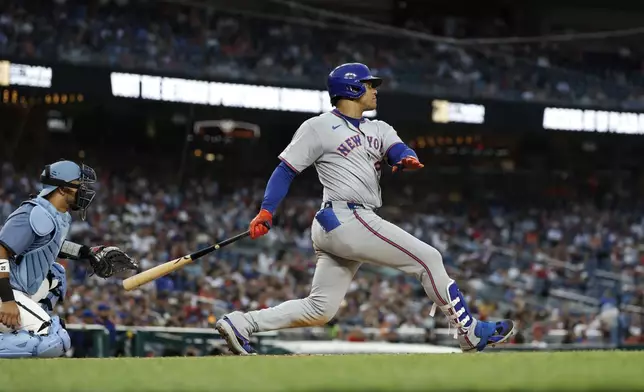 New York Mets' Juan Soto, right, follows through after hitting a single against Washington Nationals pitcher Jake Irvin during the third inning a baseball game in Washington, Friday, April 25, 2025. (AP Photo/Terrance Williams)