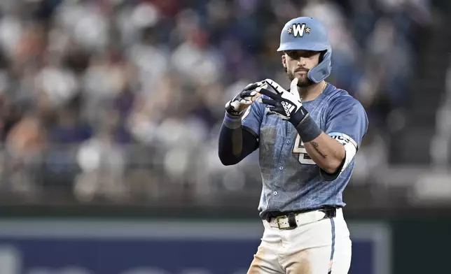 Washington Nationals' Dylan Crews gestures after hitting a double off New York Mets pitcher Kodai Senga during the second inning of a baseball game in Washington, Friday, April 25, 2025. (AP Photo/Terrance Williams)