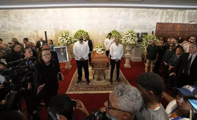 Mourners attend a memorial for Rubby Perez, the merengue singer who was performing at the Jet Set nightclub when its roof collapsed, killing more than 200 people, at the National Theater in Santo Domingo, Dominican Republic, Thursday, April 10, 2025. (AP Photo/Matias Delacroix)