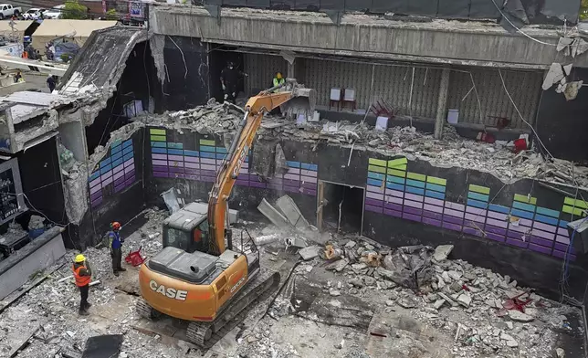 An excavator works at the site of the Jet Set nightclub days after its roof collapsed during a concert, killing more than 200 people in Santo Domingo, Dominican Republic, Thursday, April 10, 2025. (AP Photo/Matias Delacroix)
