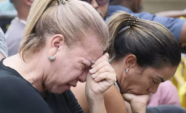 Women cry during the search for survivors at the Jet Set nightclub after its roof collapsed two nights prior during a merengue concert in Santo Domingo, Dominican Republic, Wednesday, April 9, 2025. (AP Photo/Ricardo Hernandez)