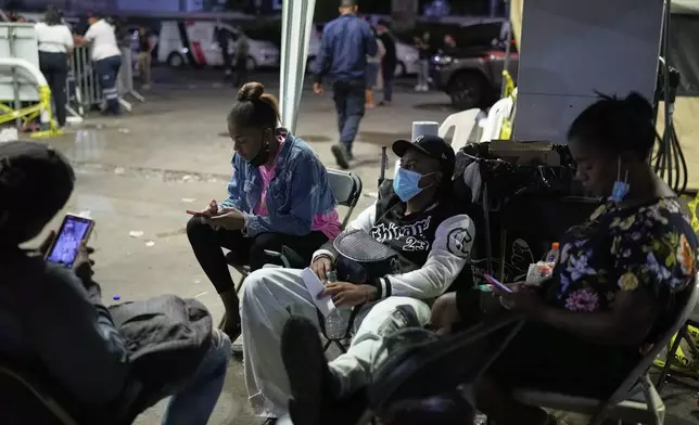 People who spent all night at the site of the Jet Set nightclub in Santo Domingo, Dominican Republic, Thursday, April 10, 2025, continue to wait for news of survivors after its roof collapsed two nights prior during a merengue concert. (AP Photo/Matias Delacroix)