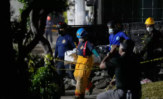 Rescue workers carry the recovered body of a victim who died when the roof collapsed two nights prior at the Jet Set nightclub during a merengue concert in Santo Domingo, Dominican Republic, Thursday, April 10, 2025. (AP Photo/Matias Delacroix)