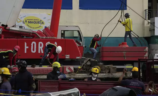 Workers prepare a crane on the third day of rescue efforts at the Jet Set nightclub after its roof collapsed during a merengue concert in Santo Domingo, Dominican Republic, Thursday, April 10, 2025. (AP Photo/Matias Delacroix)
