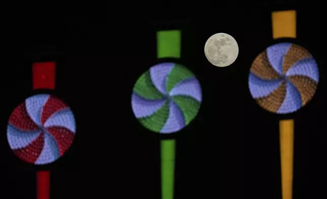 A nearly full moon rises over Rate Field during a baseball game between the Boston Red Sox and Chicago White Sox, Friday, April 11, 2025, in Chicago. (AP Photo/Erin Hooley)